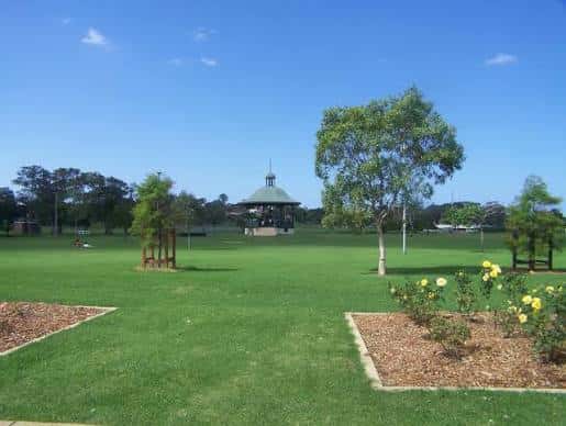 Vista panorámica de Lambton Park con césped verde y el kiosco en el fondo