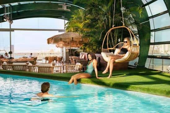 Piscina interior con zona de relax, hamacas y decoración tropical