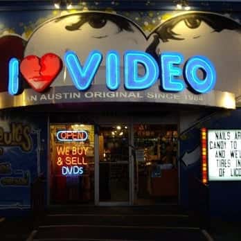 Fachada nocturna del local con letrero luminoso 'I ❤️ VIDEO'