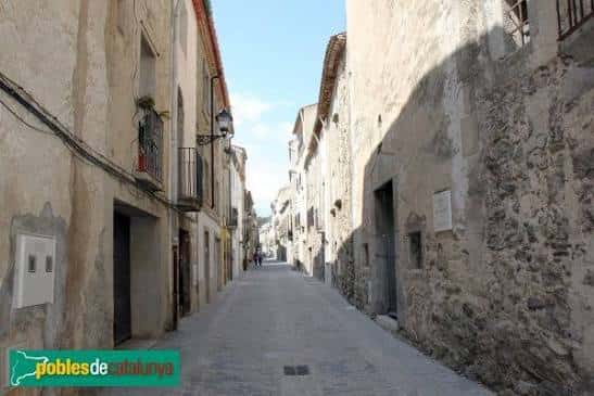 Calle empedrada del Carrer de Sant Sebastià en Maçanet de Cabrenys con arquitectura tradicional catalana