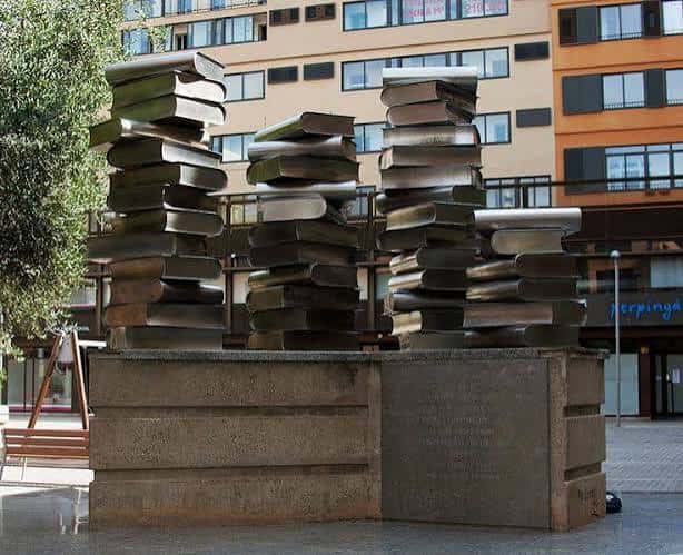Escultura de libros apilados en la plaza Josep Pla