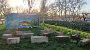 Área de descanso al aire libre con bloques de piedra frente al Aula de Natura
