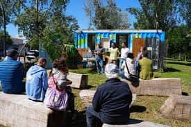 Grupo de personas sentadas en bloques de piedra durante un evento al aire libre