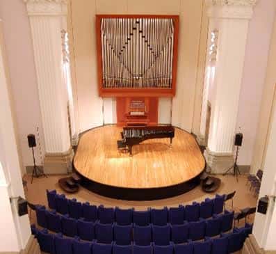 Vista cenital del escenario circular con piano y el gran órgano en la pared trasera