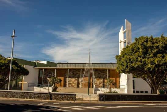 Fachada moderna de la Plaza de Finca España con torre blanca y cielo azul
