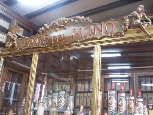 Interior histórico con estanterías de vidrio y botellas de Anís del Mono