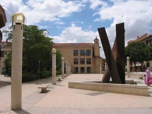 Plaza del Parque San Isidro con escultura moderna y edificios de fondo
