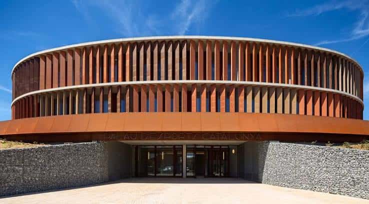Vista exterior del Palau d'Esports Catalunya con su distintiva fachada de madera y cielo azul