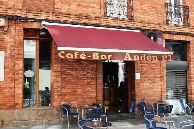 Fachada exterior del Café-Bar Andén 21 con toldo rojo y terraza