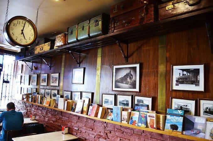 Interior del bar con decoración temática de trenes y maletas vintage
