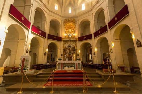 Interior de la Concatedral de San Nicolás de Bari con altar principal y decoración festiva