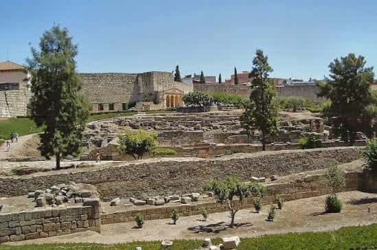 Vista panorámica de las ruinas romanas de Mérida con murallas al fondo