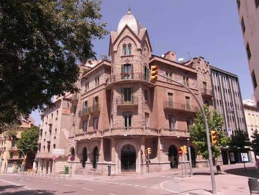 Fachada principal de la Plaça Porxada con arquitectura histórica y cúpula destacada