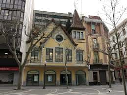 Edificio emblemático de la Plaça Porxada con tejado a dos aguas y balcones ornamentados