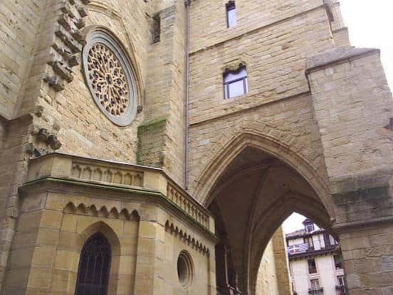 Fachada lateral de la iglesia mostrando la ventana circular y el arco de entrada