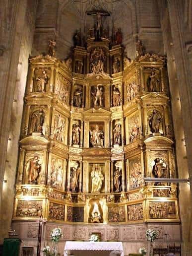 Retablo mayor dorado con múltiples esculturas religiosas en el interior de la iglesia