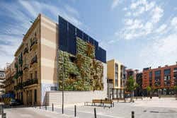 Fachada moderna con jardín vertical y arquitectura contemporánea en la plaza