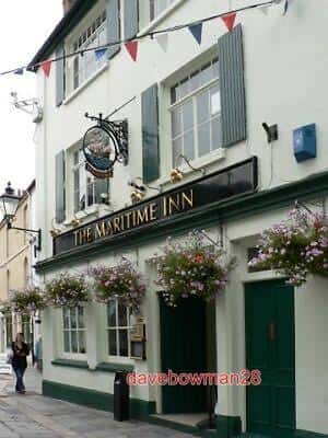 Fachada del Maritime Inn con flores colgantes y decoración festiva