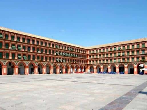 Vista panorámica de la Plaza de la Corredera con sus arcos y fachadas bajo un cielo despejado