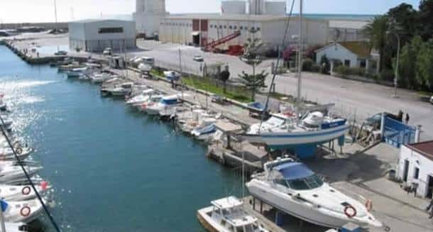 Muelle lateral del puerto con barcos en dique seco y edificios industriales en el entorno