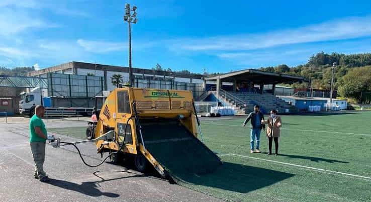 Instalación de nueva hierba artificial en el campo del Carregal con maquinaria y personal trabajando