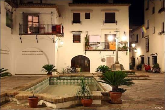 Plaza central de la urbanización con fuente decorativa y arquitectura tradicional andaluza