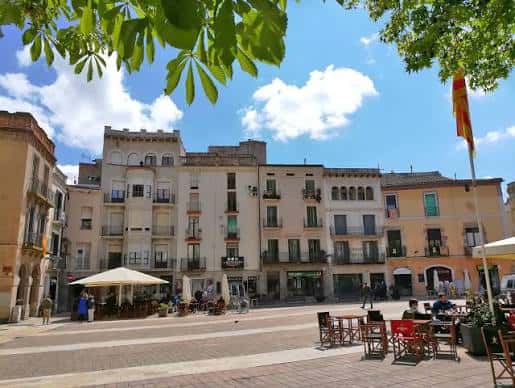 Vista panorámica de la plaza con edificios históricos y terrazas al aire libre