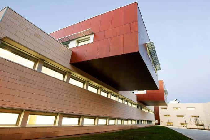 Vista exterior del Complejo Científico-Tecnológico con fachada de ladrillo y voladizo rojo