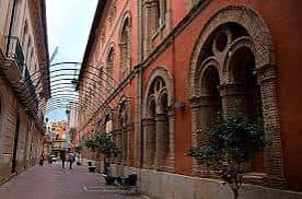 Vista exterior del edificio de las Escuelas Pías en Alzira con fachada de ladrillo y arcos decorativos
