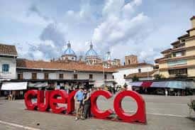 Plaza de San Bartolomé en Cuenca con letras rojas 'CUENCA' y vista de la catedral al fondo
