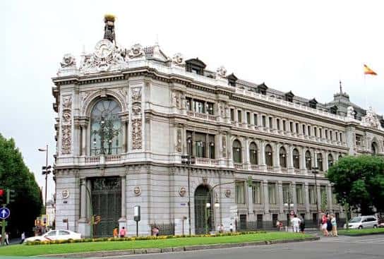 Fachada principal del Banco de España en Madrid con detalles arquitectónicos neoclásicos y bandera española