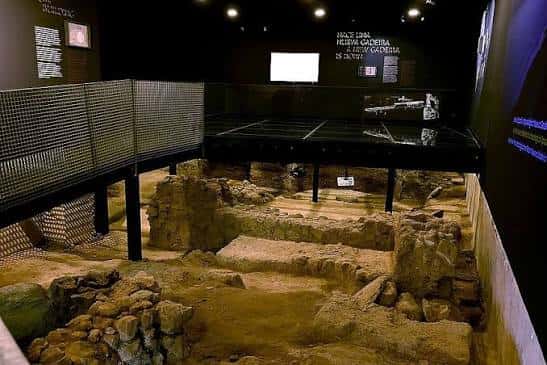 Interior del museo mostrando las ruinas arqueológicas bajo una pasarela de observación