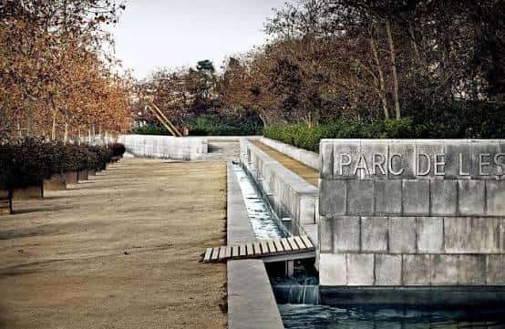 Detalle de la entrada principal con el nombre del parque grabado en piedra y un canal de agua