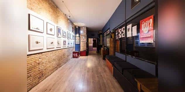 Pasillo decorado con paredes de ladrillo y exposiciones artísticas