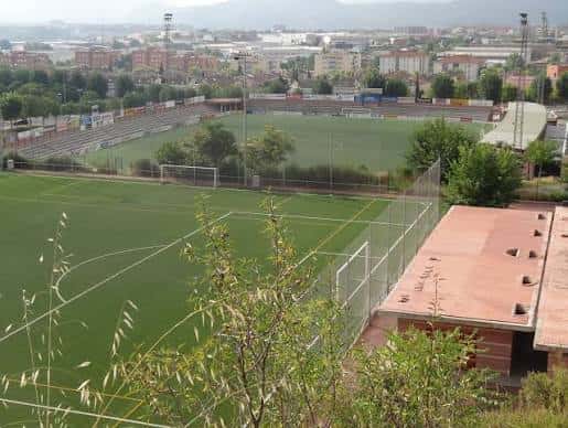 Vista panorámica del Camp de Futbol Les Comes con gradas y campo de césped