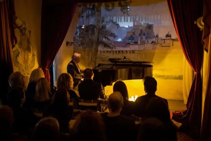 Escenario en vivo con pianista y audiencia durante una función teatral