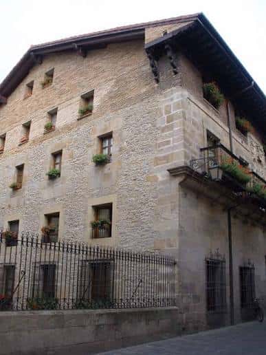 Fachada histórica de piedra con balcones y ventanas adornadas en la Calle Pintorería