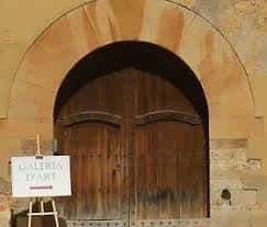 Entrada principal de la Galería d'Art La Catedral con puerta de madera y letrero