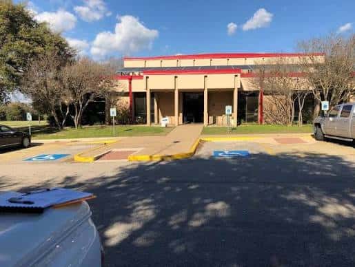 Vista exterior del South Austin Recreation Center mostrando la entrada principal y el estacionamiento