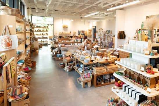 Interior espacioso y luminoso de la tienda Take Heart con estanterías de madera y productos artesanales organizados