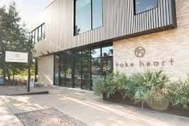 Fachada exterior moderna de Take Heart en Austin con señalización clara y diseño arquitectónico contemporáneo