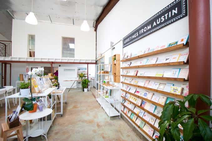 Interior del Paper + Craft Pantry mostrando estanterías de tarjetas y zona de eventos