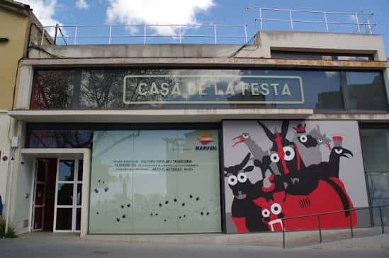 Fachada exterior de la Casa de la Festa con cartel y murales