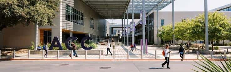 Vista panorámica de la entrada principal del campus con estudiantes caminando