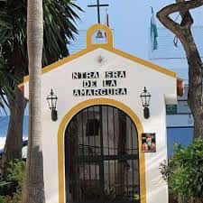 Capilla La Ansgara en la plaza, con su fachada blanca y amarilla bajo el sol