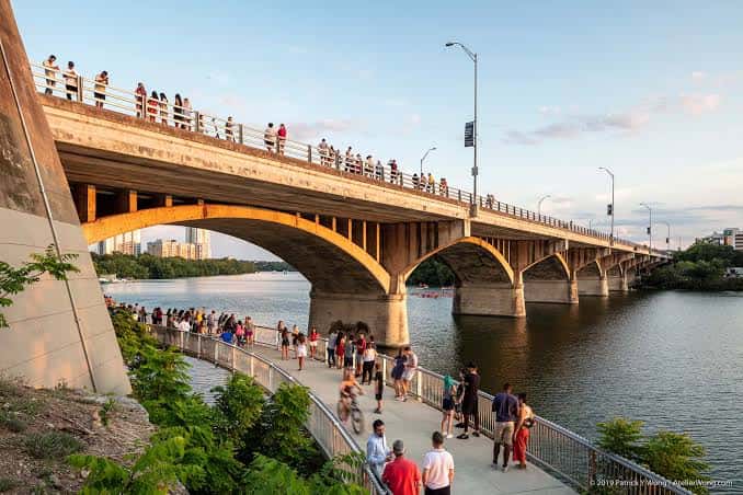 Vista panorámica de la Puente Ann W. Richards durante el atardecer con personas observando los murciélagos