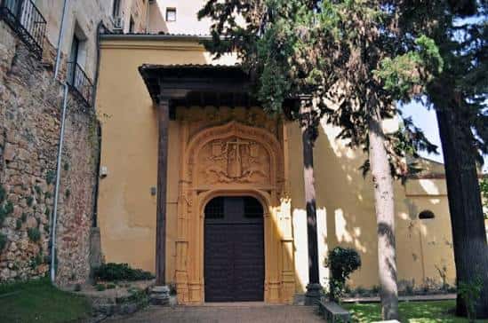 Fachada exterior de la Cueva de Santo Domingo con puerta de madera y detalles arquitectónicos