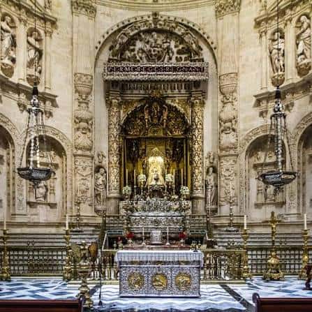 Vista frontal del altar principal de la Capilla Real con detalles ornamentales en mármol y dorados