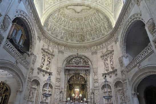 Interior de la Capilla Real mostrando la cúpula decorada y el altar central desde una perspectiva elevada