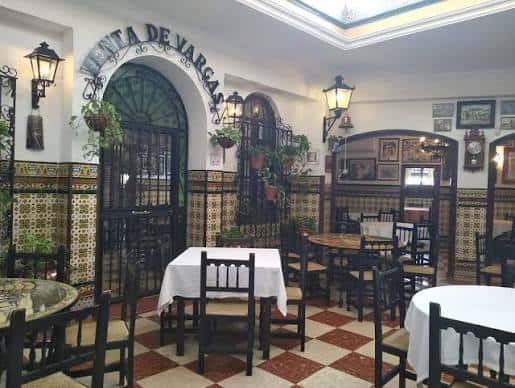 Interior del restaurante con mesas dispuestas para eventos y decoración típica andaluza